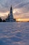 The Orthodox Church at sunset in winter in the field