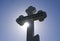 Orthodox cross against the blue sky and the sun. Cross in the backlight of the sun. Symbol of the Christian faith. The inscription