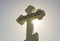 Orthodox cross against the blue sky and the sun. Cross in the backlight of the sun. Symbol of the Christian faith. The inscription