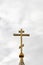 Orthodox cross on the background of a cloudy sky. Vertical photograph of the church cross