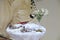 Orthodox cross, crowns for the bride and groom, the Bible, wedding rings on the pillow, candles, a glass of wine, orchids in a vas