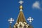 Orthodox crosses on a gold dome on a blue sky background on the Church of the Resurrection in Sokolniki, Moscow, Russia.
