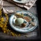 Orthodox Easter table setting with vintage plates with green ornament, forks, dyed eggs, quail eggs, yellow flower