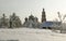 Orthodox monastery with snow covered domes in snowy area with bare trees