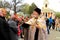 Orthodox priest in church clothes sprinkles the parishioners on Easter near the church. Religious rite, holiday Baptism