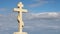 Orthodox stone cross against blue sky background, belief in God, religion