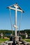 Orthodox water source Gremyachy and wooden church. Wooden monument orthodox cross on a blue sky background (not a cemetery)