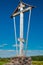 Orthodox water source Gremyachy and wooden church. Wooden monument orthodox cross on a blue sky background (not a cemetery)