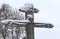 Orthodox wooden cross with a crucifix, sprinkled with snow, against the background