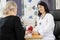 Orthopedic Doctor Looking At Female Patient At Desk