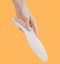 Orthopedic insole  on an orange background. Medical insoles. Treatment and prevention of flat feet and foot