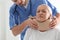 Orthopedist applying cervical collar onto patient`s neck in clinic, closeup