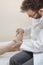 Orthopedist doctor examines the foot of an old woman lying on a bed.