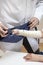 Orthopedist doctor puts a sling on the bandaged woman`s hand