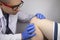 An orthopedist examines the knee of a patient who complains of acute pain. Diagnostics and treatment of cartilage tissue diseases