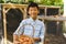 ortrait of asian boy smiling and holding basket, collecting eggs from hen house in garden