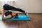 Ortrait of beautiful young woman working out at home in living room, doing yoga or pilates exercise on mat