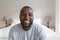 ortrait of happy african american man looking at camera and smiling in bedroom