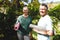 ortrait of happy senior caucasian couple holding yoga mats, looking to camera in sunny garden