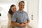 ortrait of happy senior caucasian couple in living room, embracing and smiling