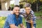 ortrait of smiling caucasian father and son embracing outside house in garden