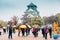 Osaka Castle and people with colorful umbrella at rainy day in Osaka, Japan