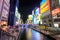 Osaka, Japan - Nov 11 2017 : Tourists traveling and vessel cruising activity with landmark Glico Man sign billboard in Dotonbori