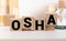 OSHA Occupational Safety and Health Administration. Safety first work background on a wooden cubes