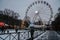 Oslo / Norway - December 05 2018: Old man look at children with ice skate in Christmas carnival with ferris wheel