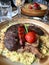 Osso Buco, Veal Shanks that are Braised in Wine with Saffron Risotto, Roasted Red Pepper and Rosemary.