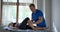 Osteopathic physician is massaging of calf muscle of female patient in modern clinic