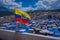 OTAVALO, ECUADOR, NOVEMBER 06, 2018: Beautiful Ecuadorian flags waving in a gorgeous sunny day with huts located in the
