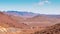 Otherworldly Landscape with mountains and reddish land and infinite road that crosses them. High Atlas, Morocco