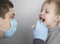 An otolaryngologist examines a child`s throat with a wooden spatula. A possible diagnosis is inflammation of the pharynx, tonsils