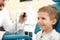 Otolaryngologist examining little boy\'s ear with ENT telescope in hospital