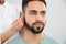 Otolaryngologist putting hearing aid in man`s ear