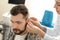 Otolaryngologist putting hearing aid in man\'s ear in hospital