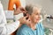 Otolaryngologist putting hearing aid in senior patient`s ear