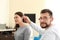 Otolaryngologist putting hearing aid in woman\'s ear indoors