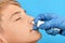 An otolaryngologist wearing blue protective gloves sprays a medicated spray into the child`s nose. Treatment of human respiratory