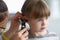 Otorhinolaryngologist examines little girl`s ear with otoscope in clinic