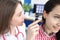Otorhinolaryngologist examines patient ear with otoscope closeup