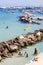 Otranto, Italy. Ionian sea with rocks, harbor, boats and people on vacation.