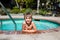 Oudoor summer activity. Concept of fun, health and vacation. A happy boy five years old is holding onto the side of the