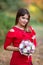 Oung beautiful girl in red dress with bouquet in hands