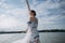 ?oung girl stands on a yacht with white sails in a flying dress