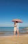 Oung lovers guy and girl on the seashore kiss under a large beach umbrella