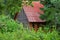 Ð¡ountry house with a red roof buried in the foliage of trees in summer