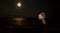 Ð¡ouple kissing at the beach under moonlight