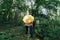 Ð¡ouple in love under yellow umbrella in a forest